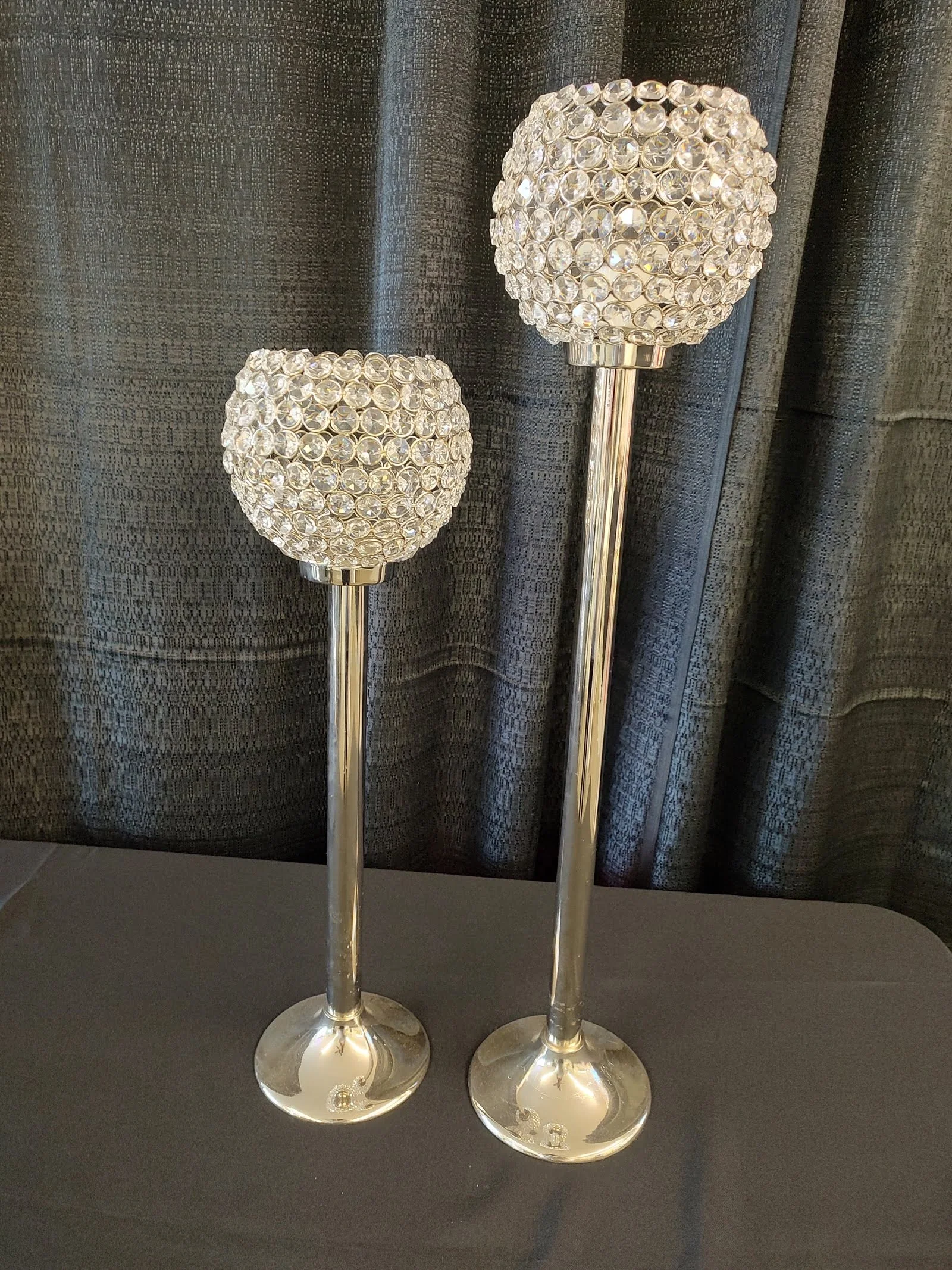 Two elegant silver candle holders with crystal-like embellishments.