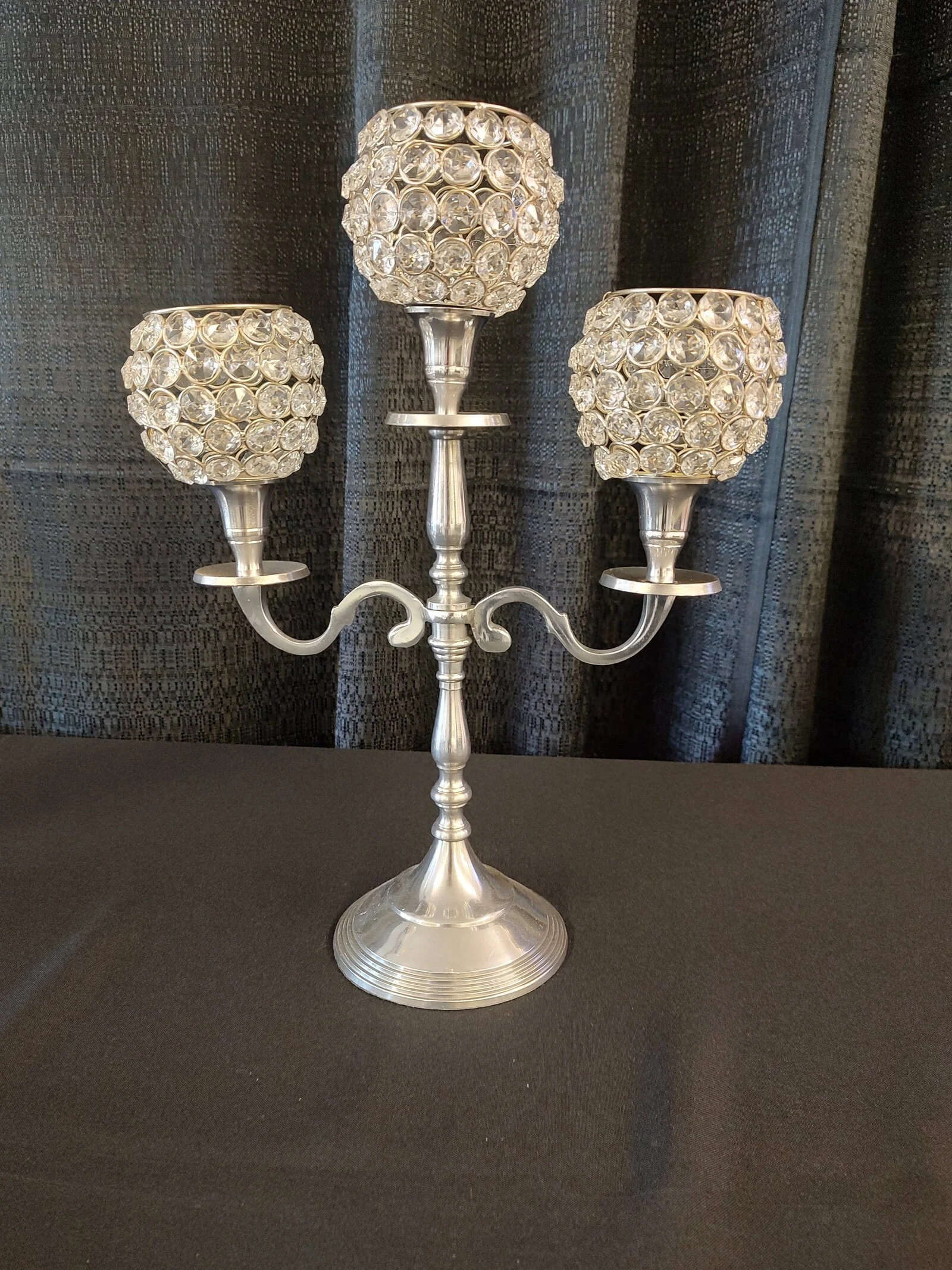 Elegant three-arm silver candelabra with crystal candle holders.