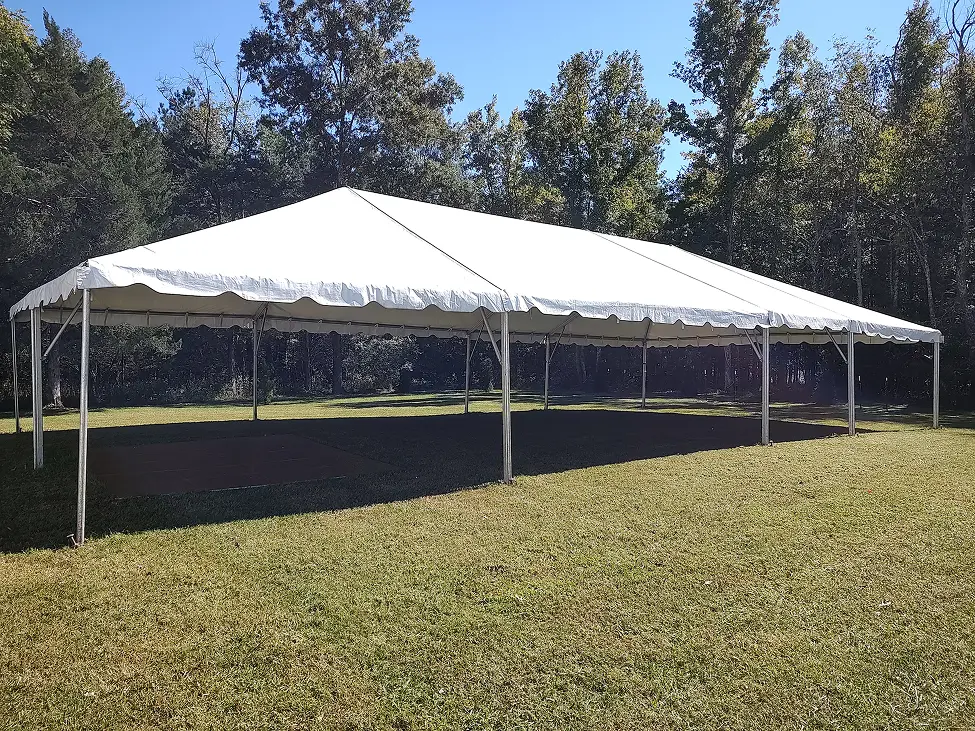 Large white outdoor event tent set up on green grass.