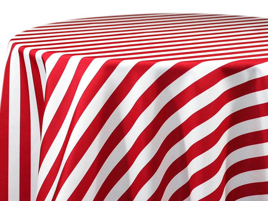 Red and white striped tablecloth draped over a round table.