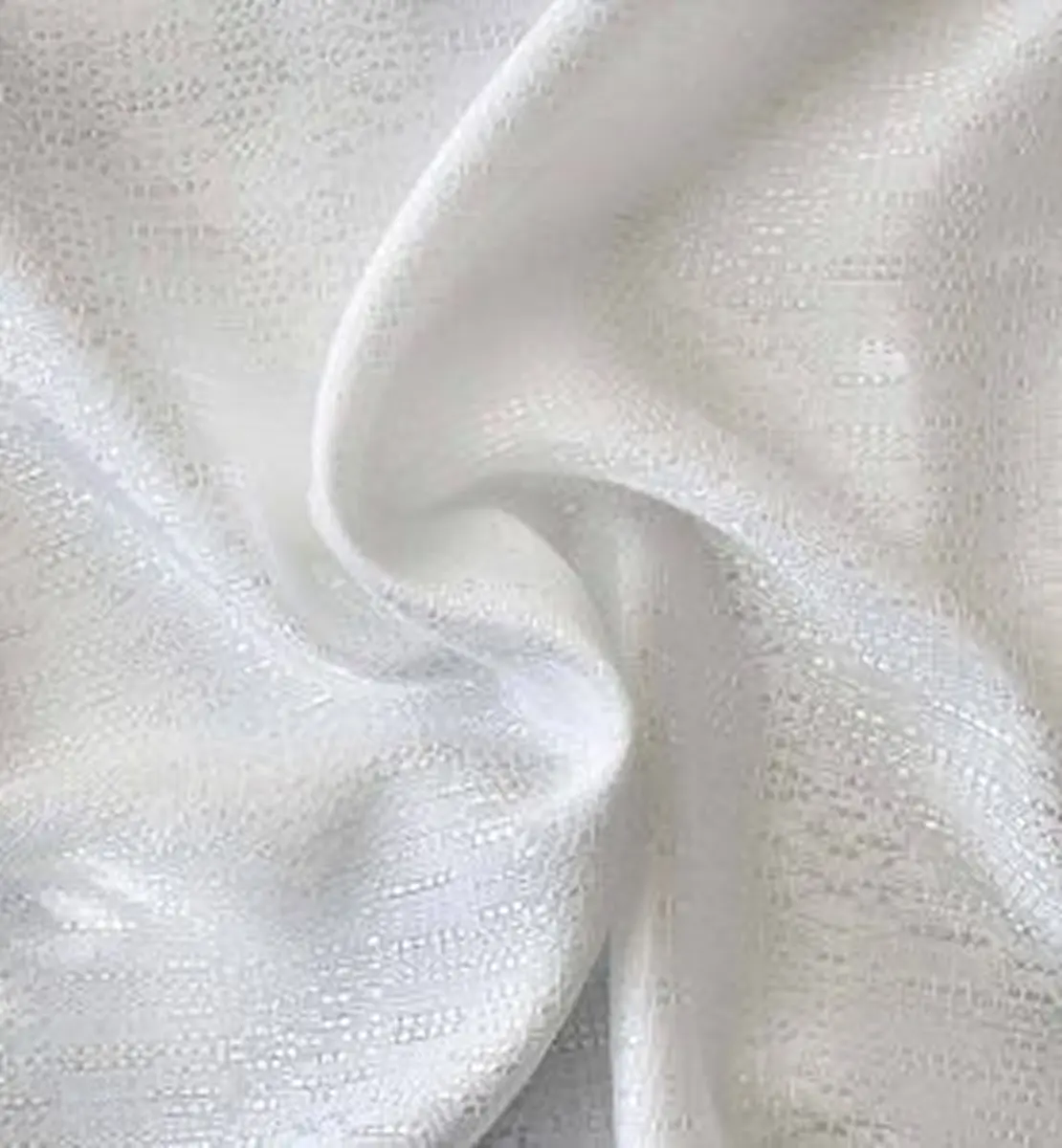 Close-up of soft, white fabric with a subtle textured pattern.
