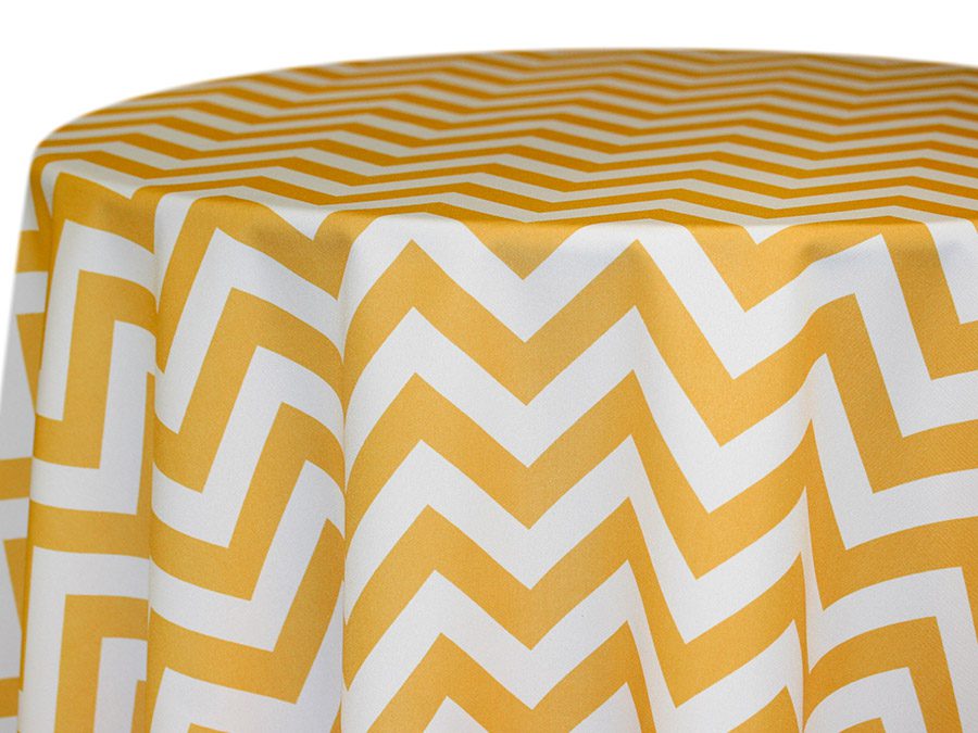 Round table with yellow and white zigzag patterned tablecloth.