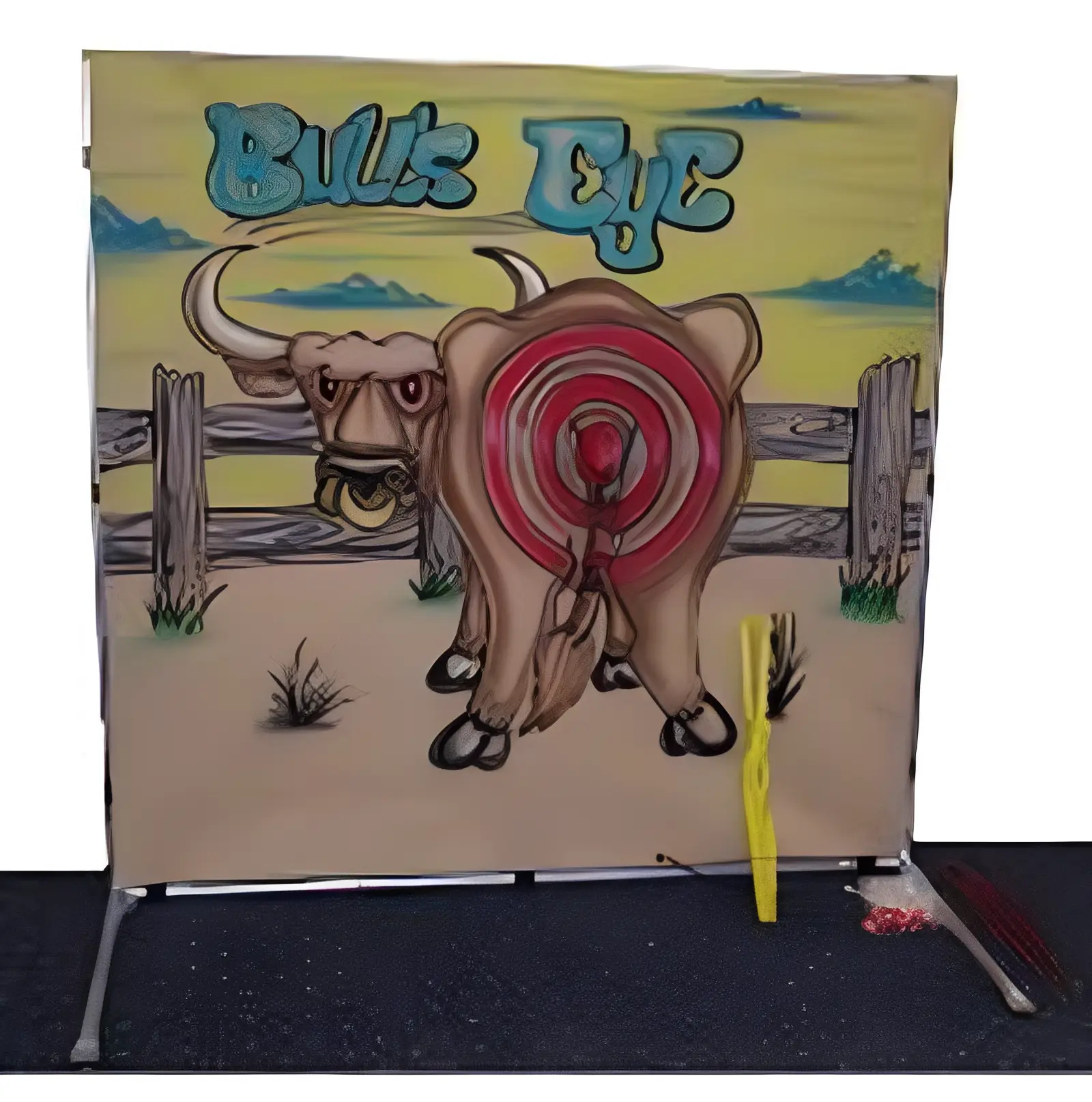 A cow with a target painted on its rear end in a carnival game setup.