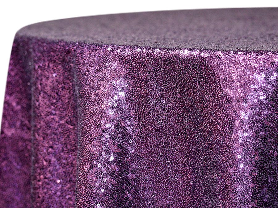 Close-up of a purple sequin-covered fabric with shimmering texture.