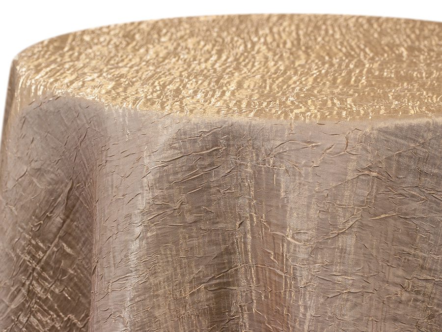 A textured beige tablecloth draped over a round table.
