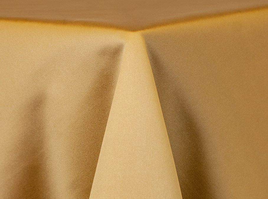 Close-up of beige fabric with distinct folds and shadows.