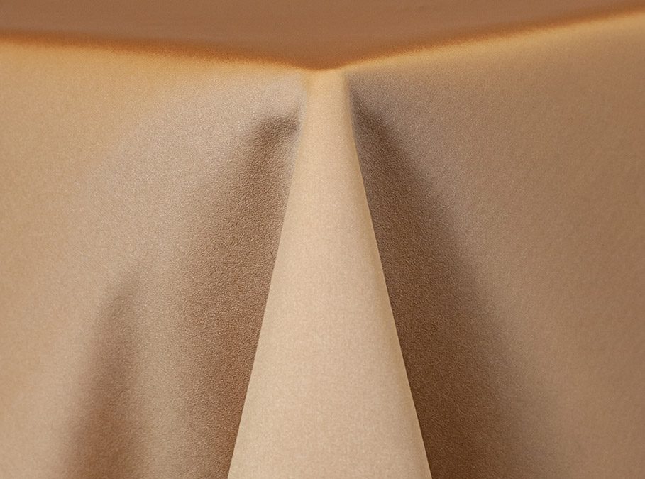 Close-up of beige fabric with a central fold creating a peak.