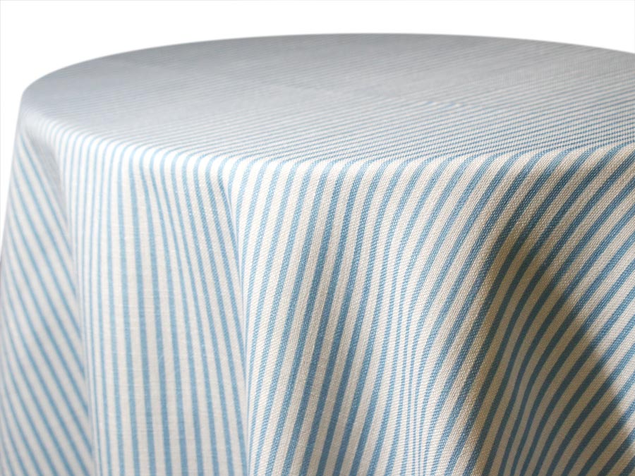 Round table with a striped tablecloth in soft colors.