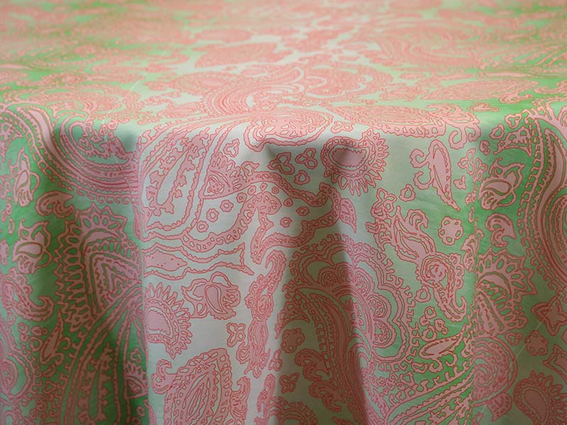 A table covered with a pink and green patterned tablecloth.