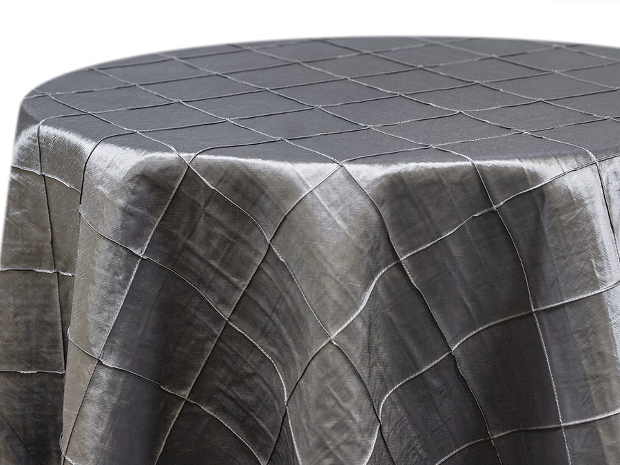 Round table covered with a textured gray fabric tablecloth.