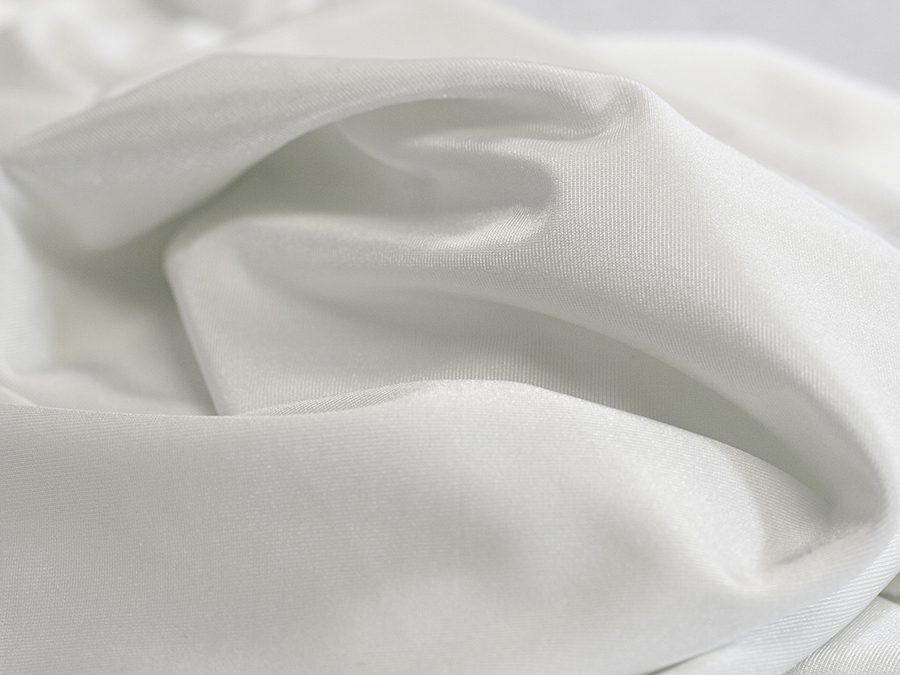 Soft white fabric with gentle folds and smooth texture.