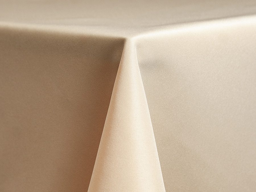 Close-up of a beige tablecloth corner draped over a table.