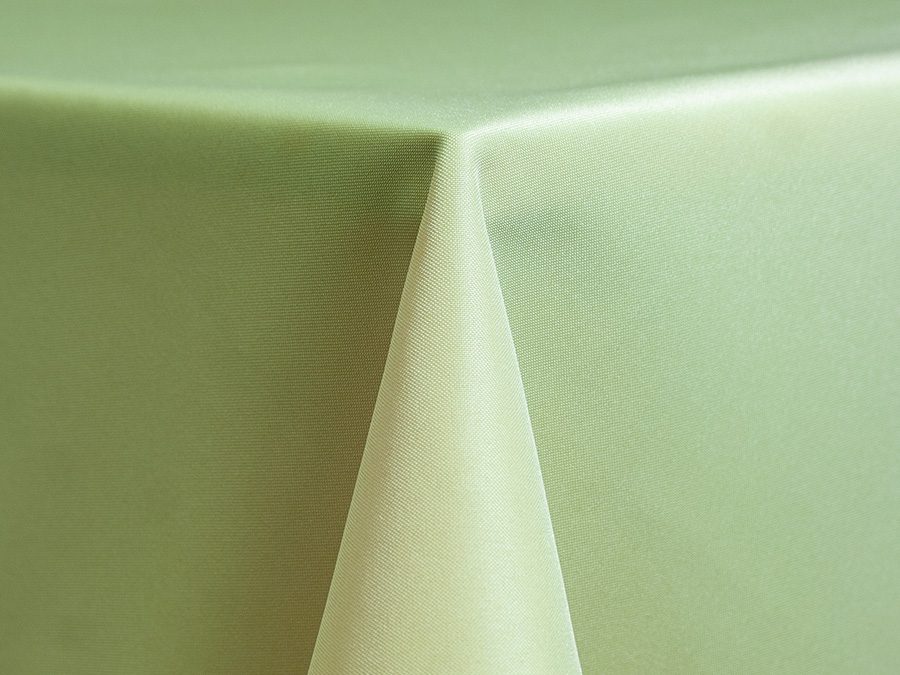 Close-up of a green tablecloth corner draped over a table.