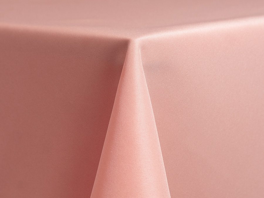 Close-up of a pink tablecloth draped over a corner of a table.