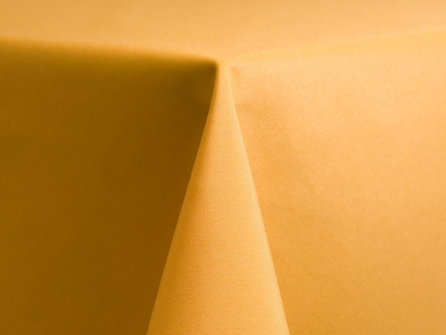 Close-up of a golden-yellow fabric with a sharp fold.
