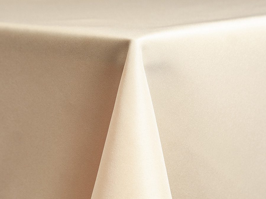 Close-up of a beige tablecloth draped neatly over a corner.