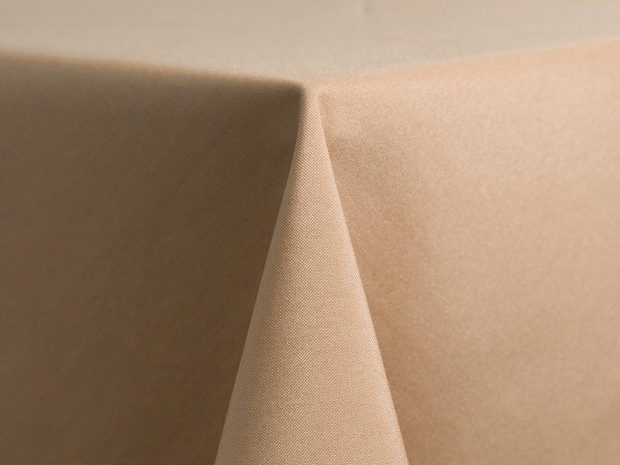 Close-up of a beige tablecloth corner draping over a table edge.