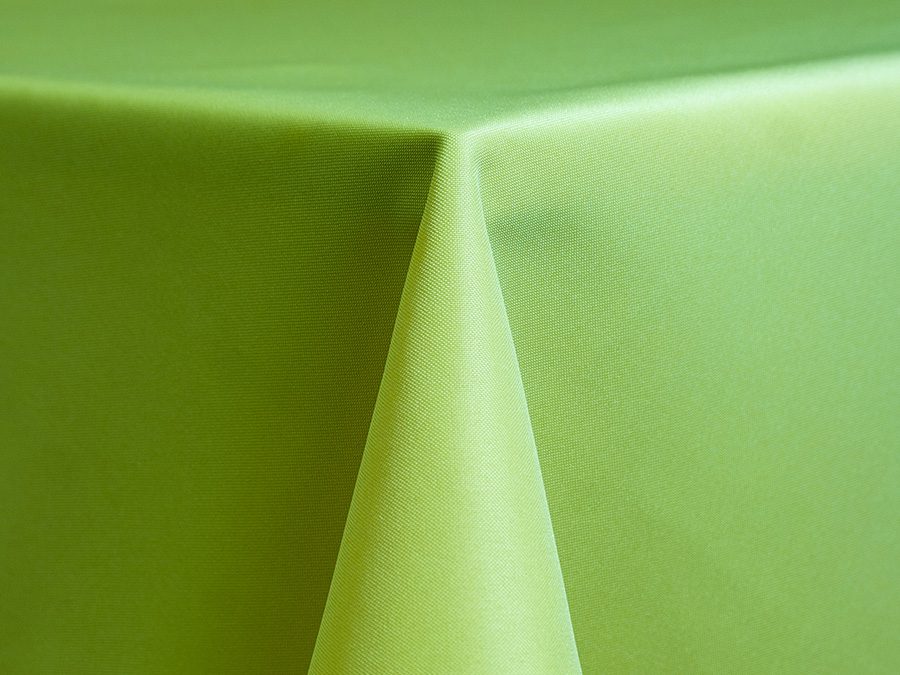 Close-up of a green tablecloth draped over a table corner.