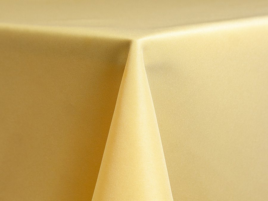 Close-up of a neatly folded beige tablecloth corner.