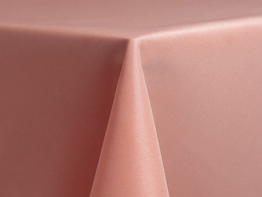 Close-up of a pink tablecloth corner draped over a table.