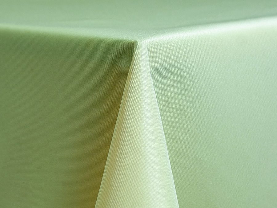 Close-up of a green tablecloth draped over a corner of a table.