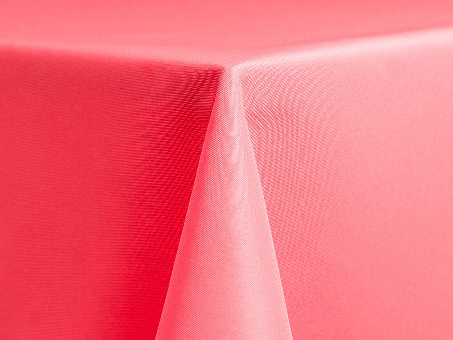 Close-up of a red tablecloth corner hanging over a surface.