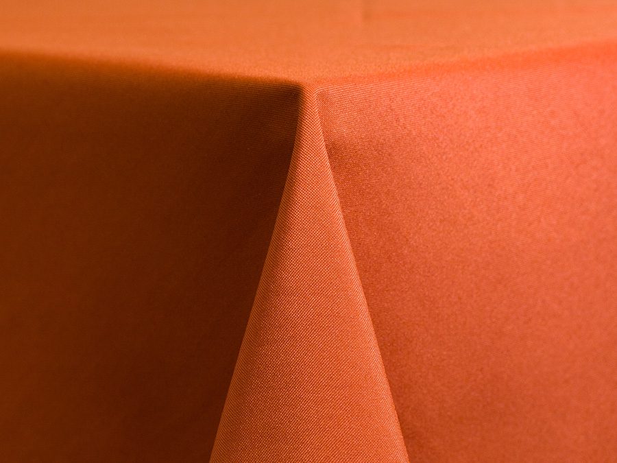 Close-up of an orange fabric with a sharp fold.