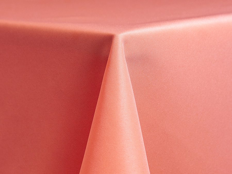 Close-up of a coral-colored fabric draped over a surface.