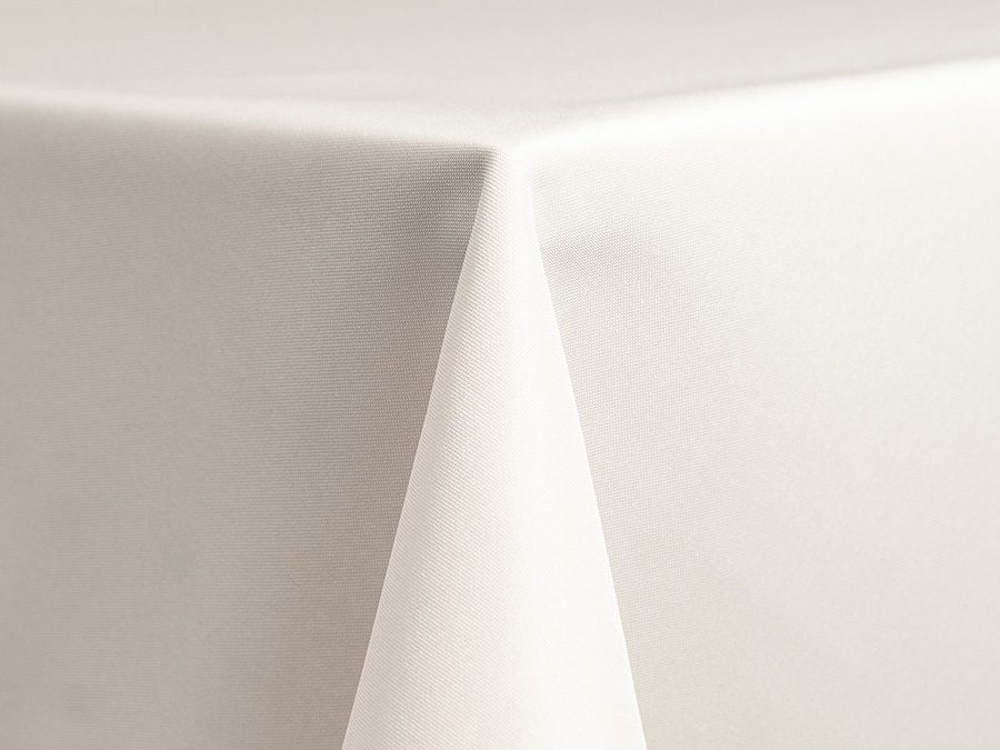 Close-up of a white tablecloth corner draped over a table.